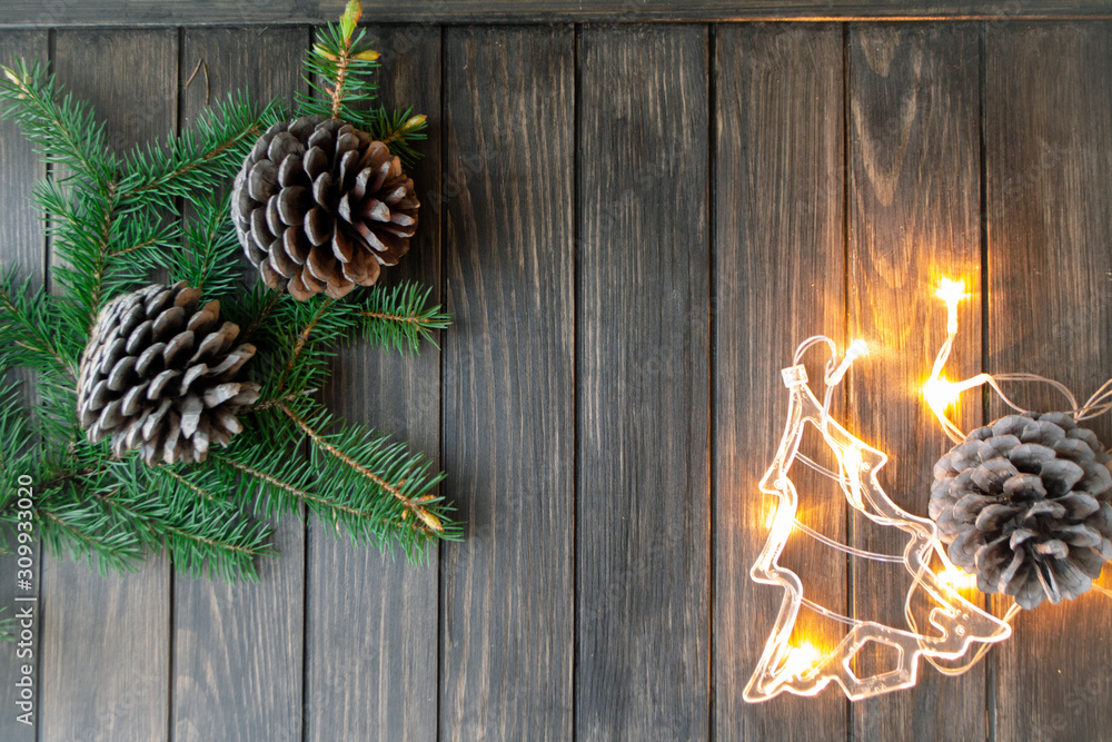 Christmas background with fir branches and pine cones, illumination garland in form of Christmas tree Christmas background with fir branches and pine cones, illumination garland in form of Christmas tree