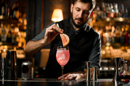Bartender adding grapefruit slice in a drink