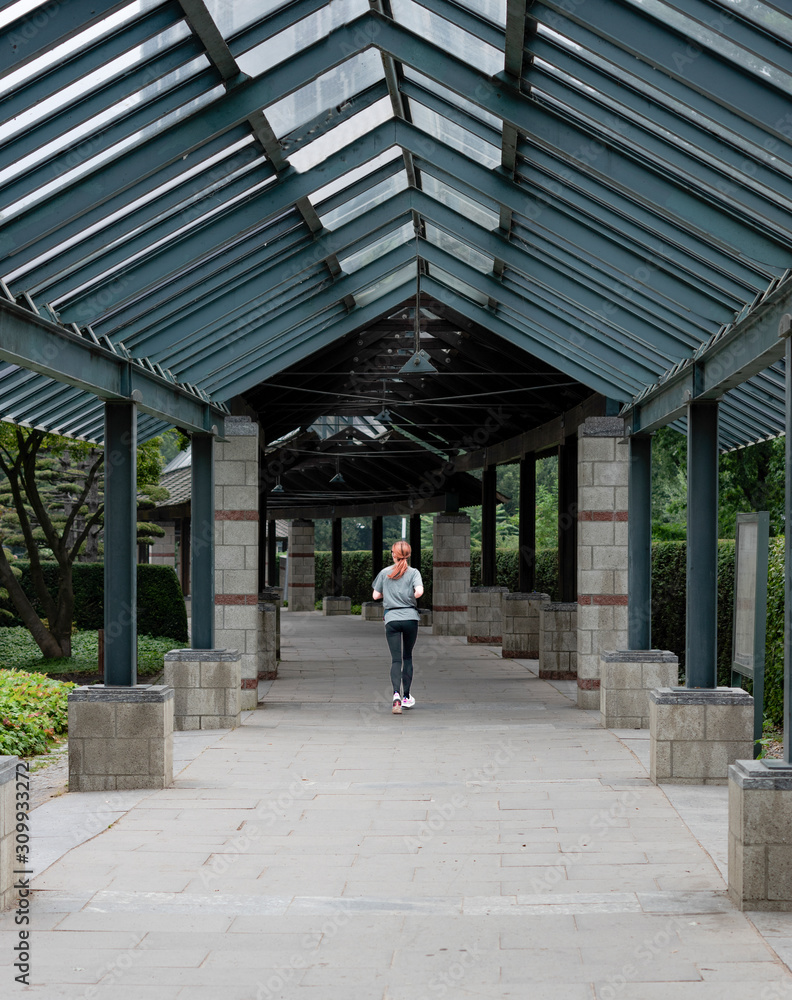 woman running through a japanese park woman running through a japanese park