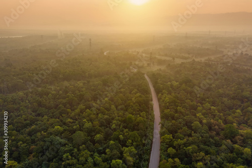 Aerial view of road or street way path with the sun on mountain hill with green natural green forest trees in Lumpang City, Thailand. photo