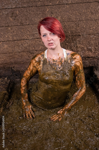 Girl Bathing in cow manure in a manure channel photo