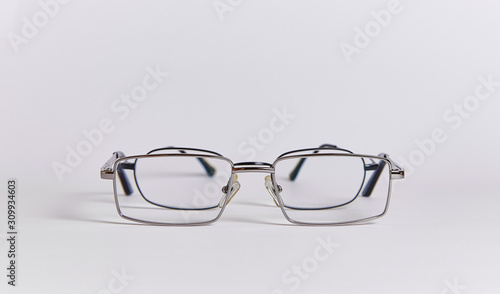 Two pairs of glasses are arranged one after another, like two people. Glasses close-up isolated on a white background