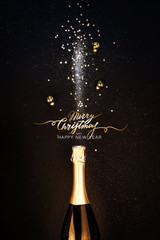 Festive Christmas background. Bottle of champagne with a spray of sparkles and Christmas decorations. Happy new year concept