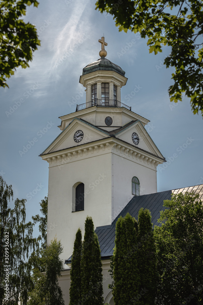 White church tower surrounded by green foliage