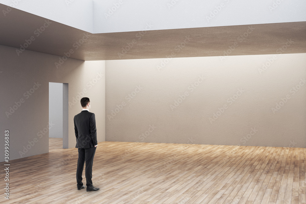 Businessman looking on empty wall Businessman looking on empty wall