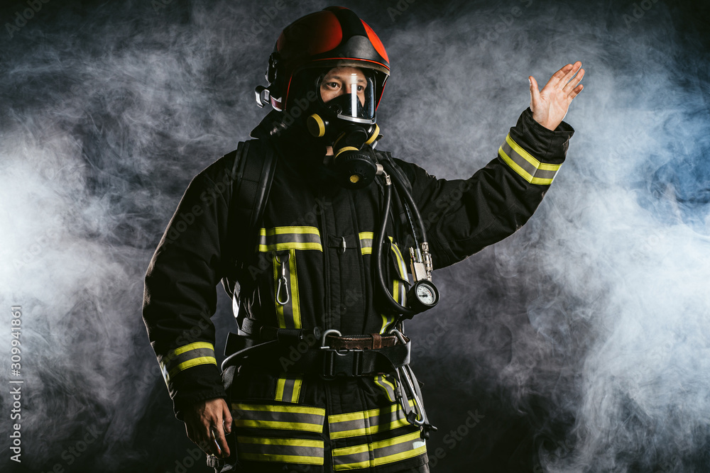 young caucasian fireman show at fire, serious male in uniform gives a signal to colleagues working with him in fire station, emergency situation young caucasian fireman show at fire, serious male in uniform gives a signal to colleagues working with him in fire station, emergency situation