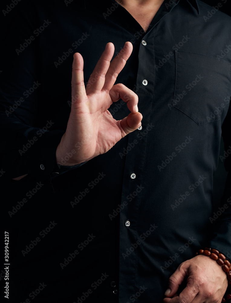 Fototapeta premium man in a black shirt shows with his hand the gian mudra