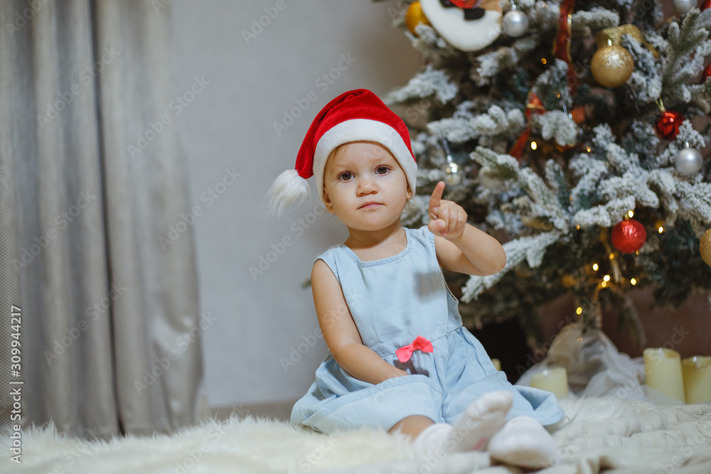 Little and beautiful girl next to a Christmas tree. Little and beautiful girl next to a Christmas tree.