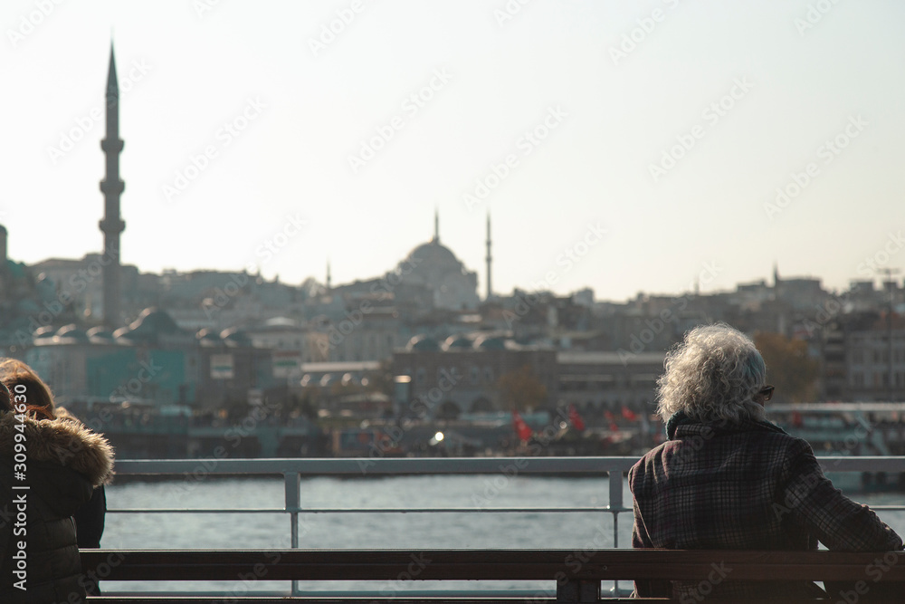 Obraz premium An elder lady travelling on city ferry and looking to Istanbul