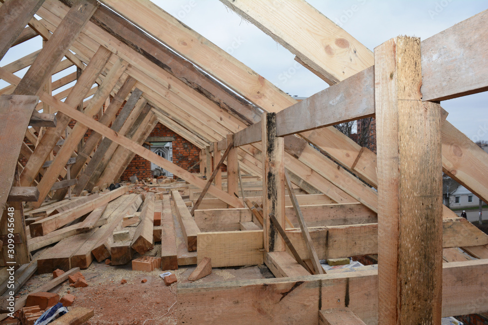 Unfinished attic house rooftop roofing construction attic trusses, frame wooden beams, eaves, timber. Unfinished attic house rooftop roofing construction attic trusses, frame wooden beams, eaves, timber.