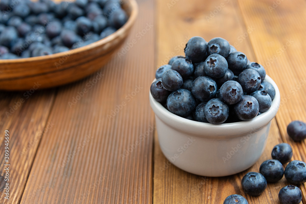 Ripe blueberries in the bowl on the wooden table. Fresh berries for breakfast. Ripe blueberries in the bowl on the wooden table. Fresh berries for breakfast.