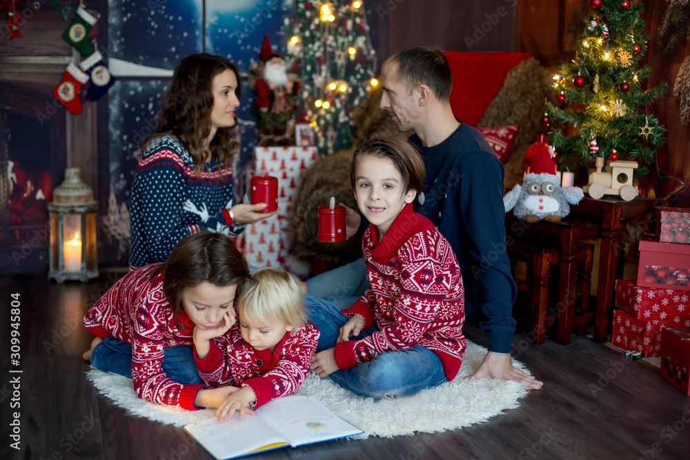 Happy smiling family, mom, dad and three boys, having family portrait at home for Christmas Happy smiling family, mom, dad and three boys, having family portrait at home for Christmas