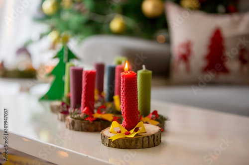 Close shot of natural handmade candles made of beeswax on a wood with christmas decoration