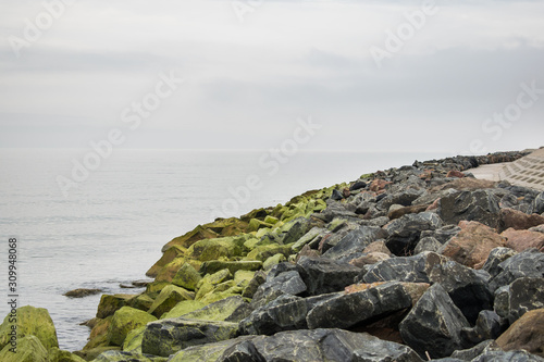 Granite revetment or seawall on the shore. Big boulders to protect coast from erosion. Prevent disaster.