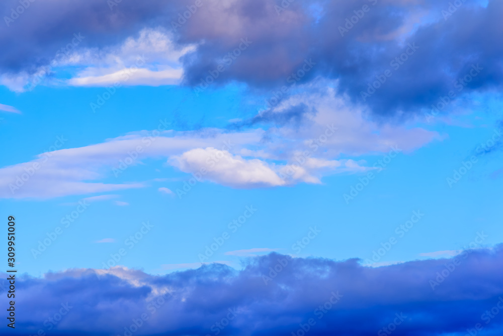 Fototapeta premium A medley of colorful clouds isolated against pastel blue skies