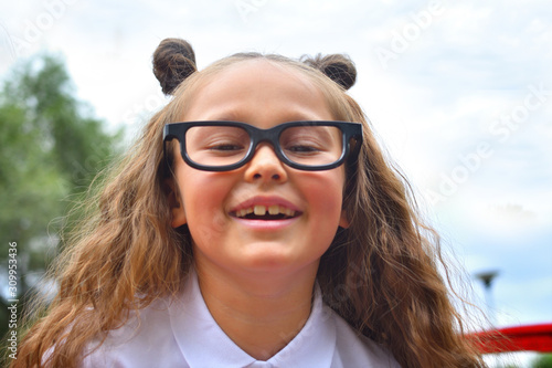 Portrait of beautiful young first-grader girl in eyeglasses. Focus on girls eyes