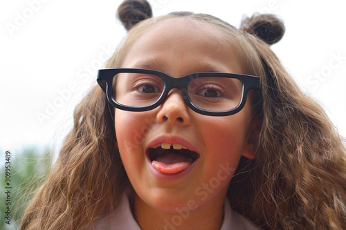 Portrait of beautiful young first-grader girl in eyeglasses. Focus on girls eyes