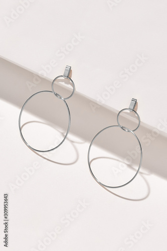 Fotografie, Tablou Subject shot of a pair of stud earrings isolated on the white geometric design surface