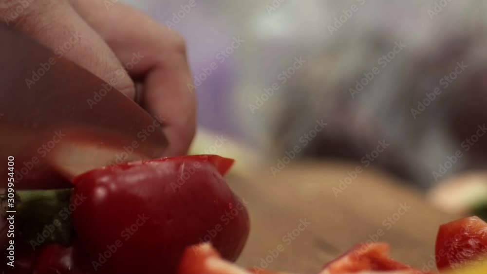 Cook hands cut a piece of red pepper. Juicy paprika slices Cook hands cut a piece of red pepper. Juicy paprika slices