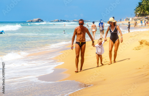 Mother and children go home from beach. Happy family resting on the sunset background. Sun kissed child