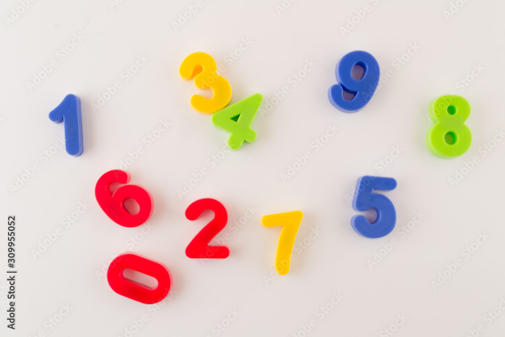 Obraz premium Colorful numbers from zero to nine randomly scattered on a white background