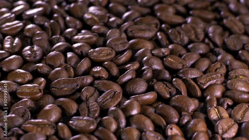 Roasted coffee bean. Fragrant coffee beans scrolls slowly around the camera. Slow Motion Close Up of Whole Roasted Coffee Beans. Roasted coffee bean. Fragrant coffee beans scrolls slowly around the camera. Slow Motion Close Up of Whole Roasted Coffee Beans.