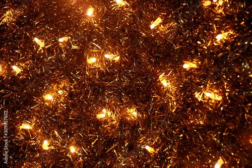 Part of Christmas decorative yellow and white flashing lights  close up. Detail of New Year and Christmas decorations  string rice lights bulbs. Ornaments to christmas celebration  holiday scene.