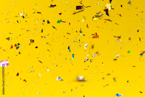 Colourful glitter drops on yellow background.