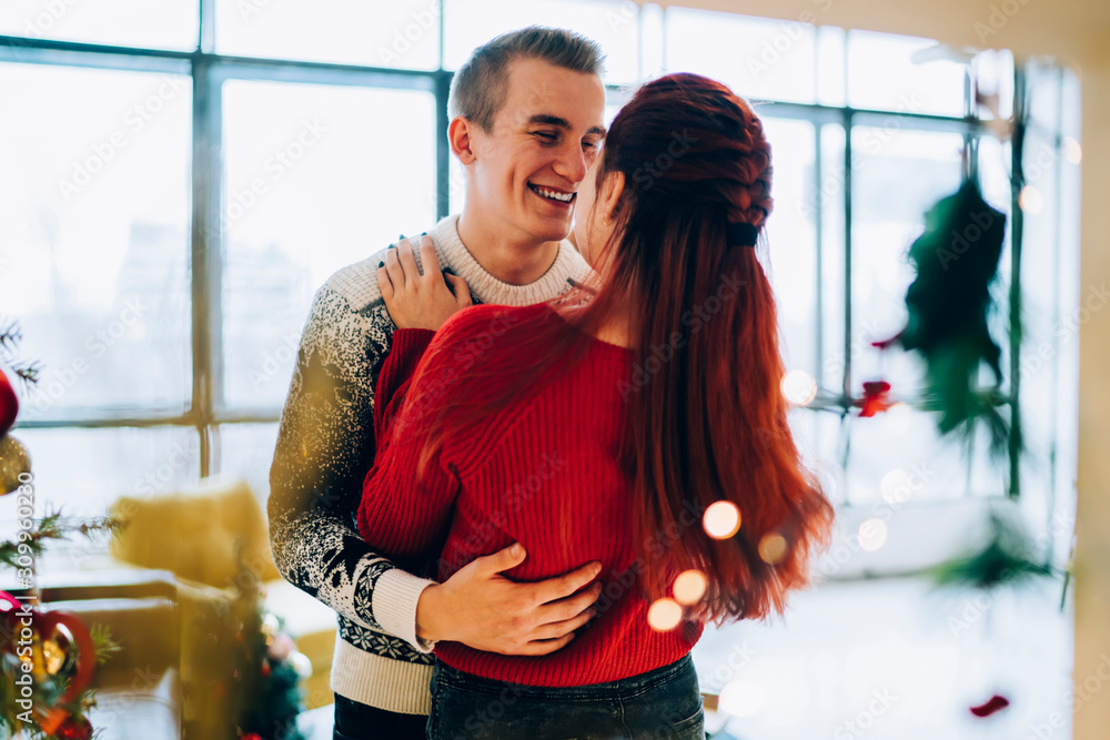 Beautiful couple hugging at home on Christmas holiday Beautiful couple hugging at home on Christmas holiday
