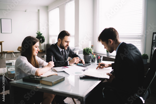 Group of coworkers sitting at table in office