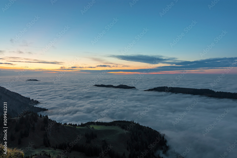 Hills above a sea of clouds at sunset. Bavaria, Germany
