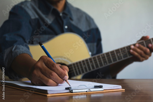 Fotografie Composer holding pencil and writing lyrics in paper
