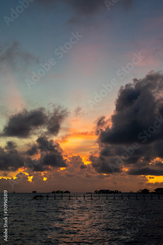 Sunset background and sun beam on the open sea with beautiful clouds.