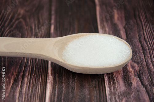 sugar in a wooden spoon on the table.