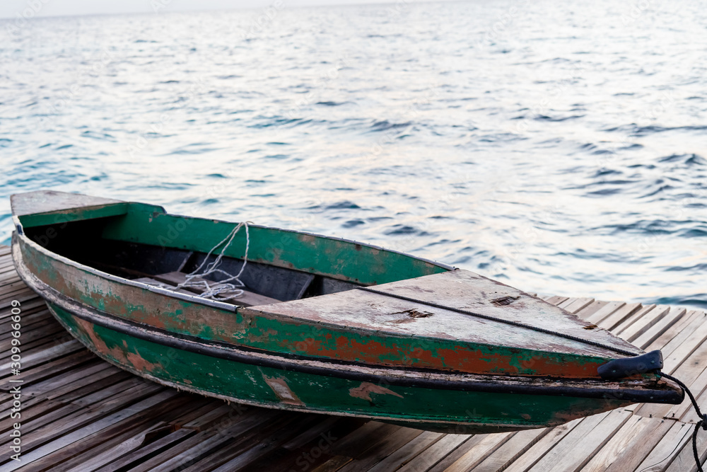 Old wooden boat sitting on the pier overlooking the beautiful Semporna turquoise sea.