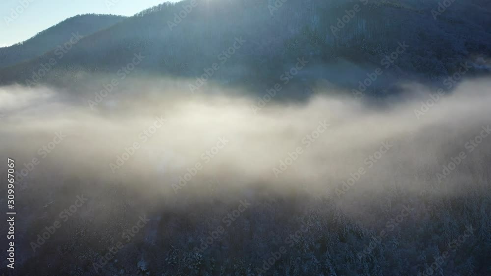 Aerial view of low lying clouds in wintery valley Aerial view of low lying clouds in wintery valley