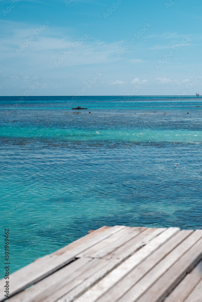 Fototapeta premium Wooden pier by the beach in tropical country.