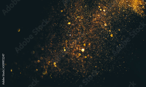 glitter vintage lights background. gold and black. de focused photo