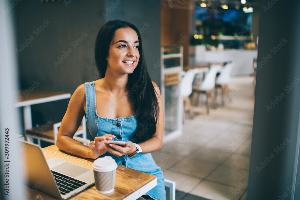 Cheerful female using smartphone in cafe Cheerful female using smartphone in cafe