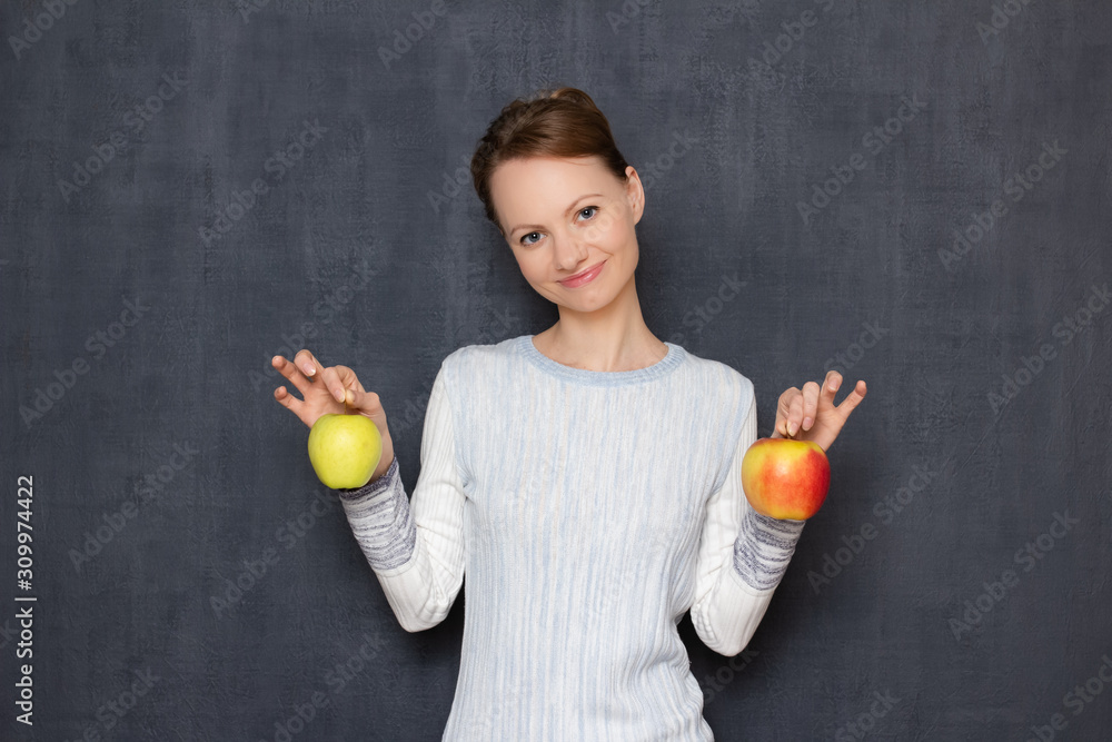 Portrait of happy young woman smiling and holding ripe apples in hands Portrait of happy young woman smiling and holding ripe apples in hands