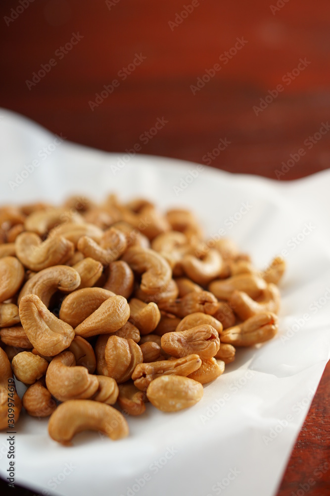 cashew nuts in a dish with wood table. cashew nuts in a dish with wood table.