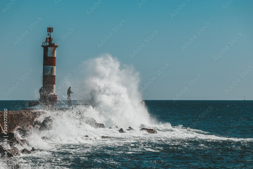 Lighthouse with a big wave crashing