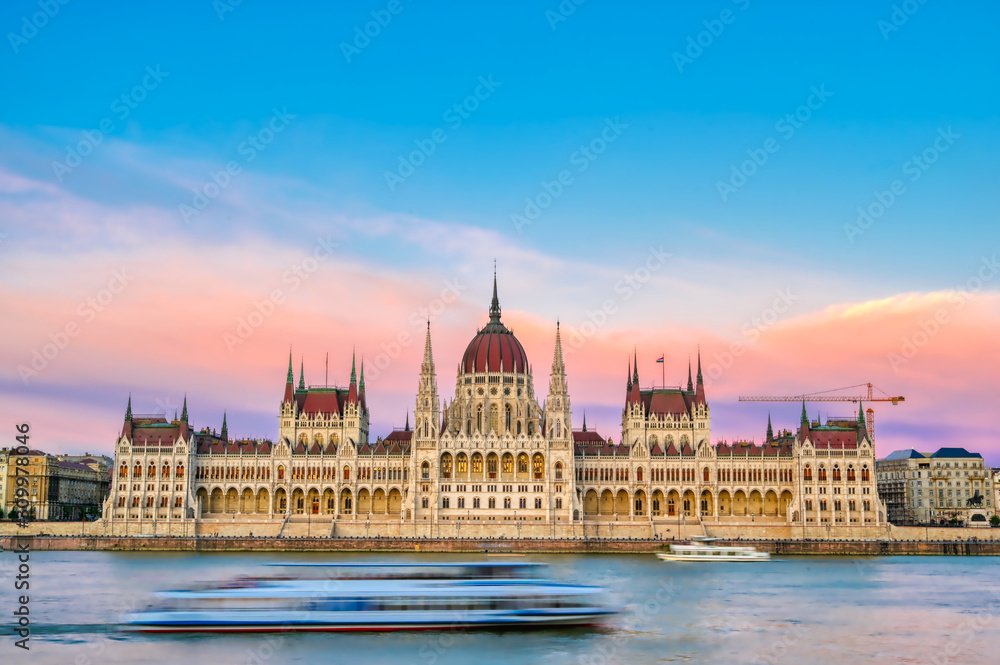 The Hungarian Parliament Building located on the Danube River in Budapest Hungary at sunset.