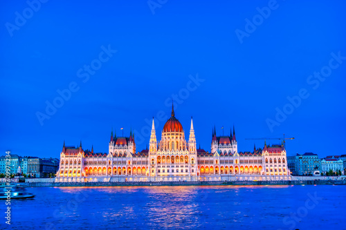 The Hungarian Parliament Building located on the Danube River in Budapest Hungary at sunset.