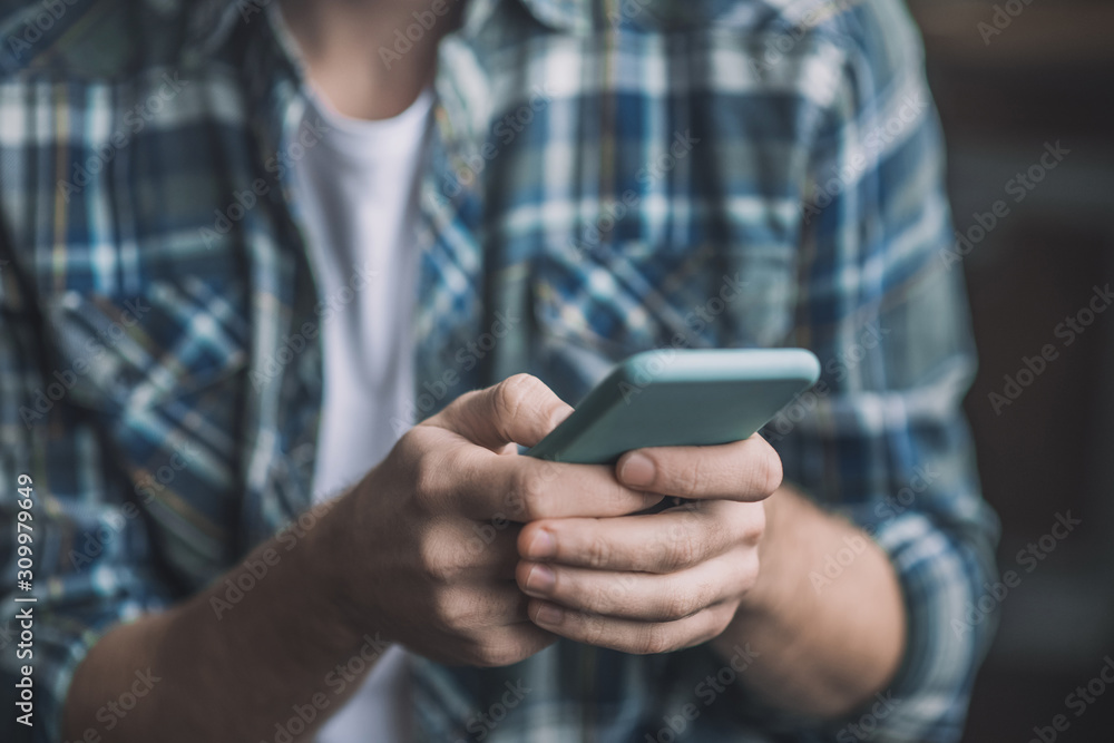 Man holding a smartphone in a blue case. Man holding a smartphone in a blue case.