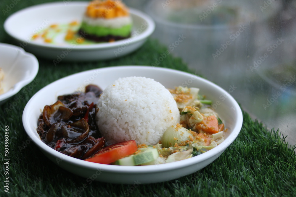 Black pepper beef served with rice and vegetable window view Black pepper beef served with rice and vegetable window view