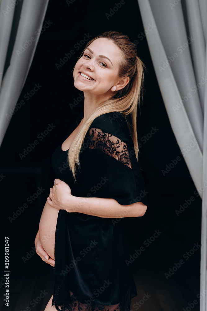 Happy young pregnant woman posing in black penny Happy young pregnant woman posing in black penny