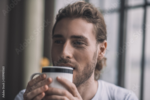 Handsome man starting his day with a cup of coffee