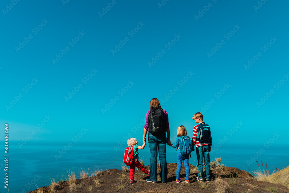 happy mom with three kids travel in mountains near sea
