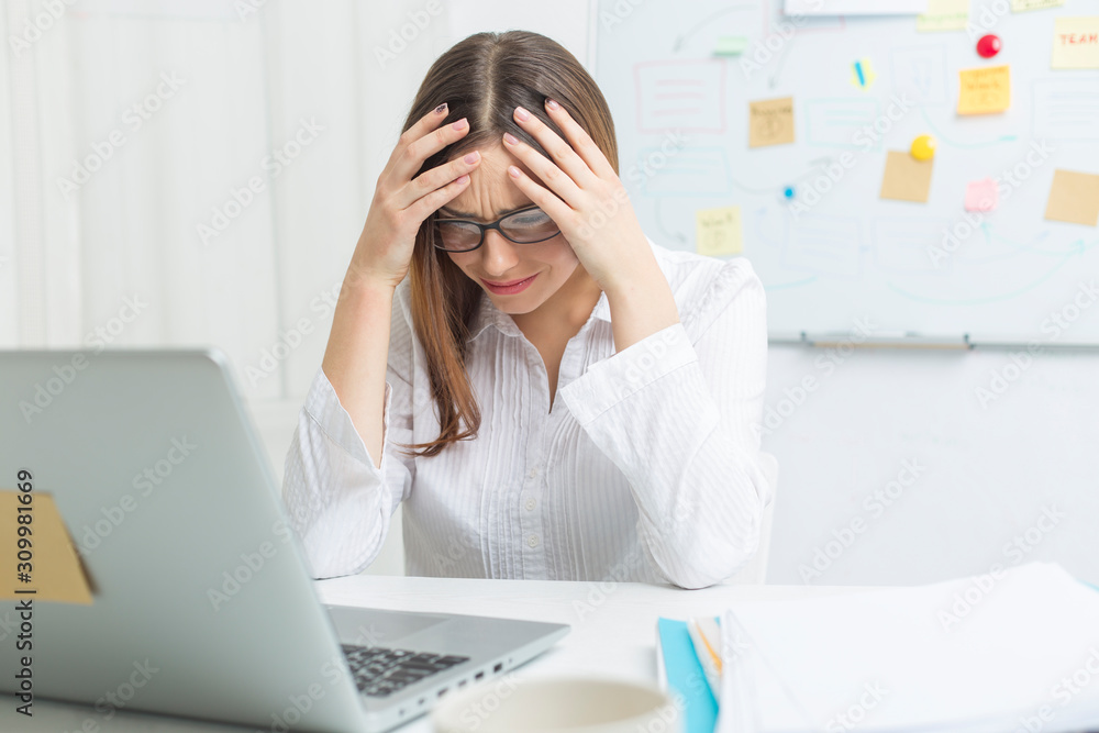 Portrait of a woman tired at work at a laptop. Headache. Portrait of a woman tired at work at a laptop. Headache.